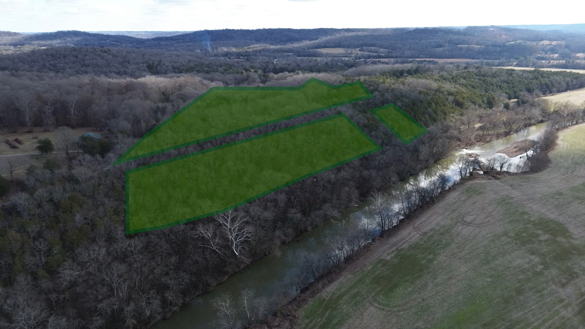 Image of vacant rural land with river trees and skyline and property outline drawn on photo